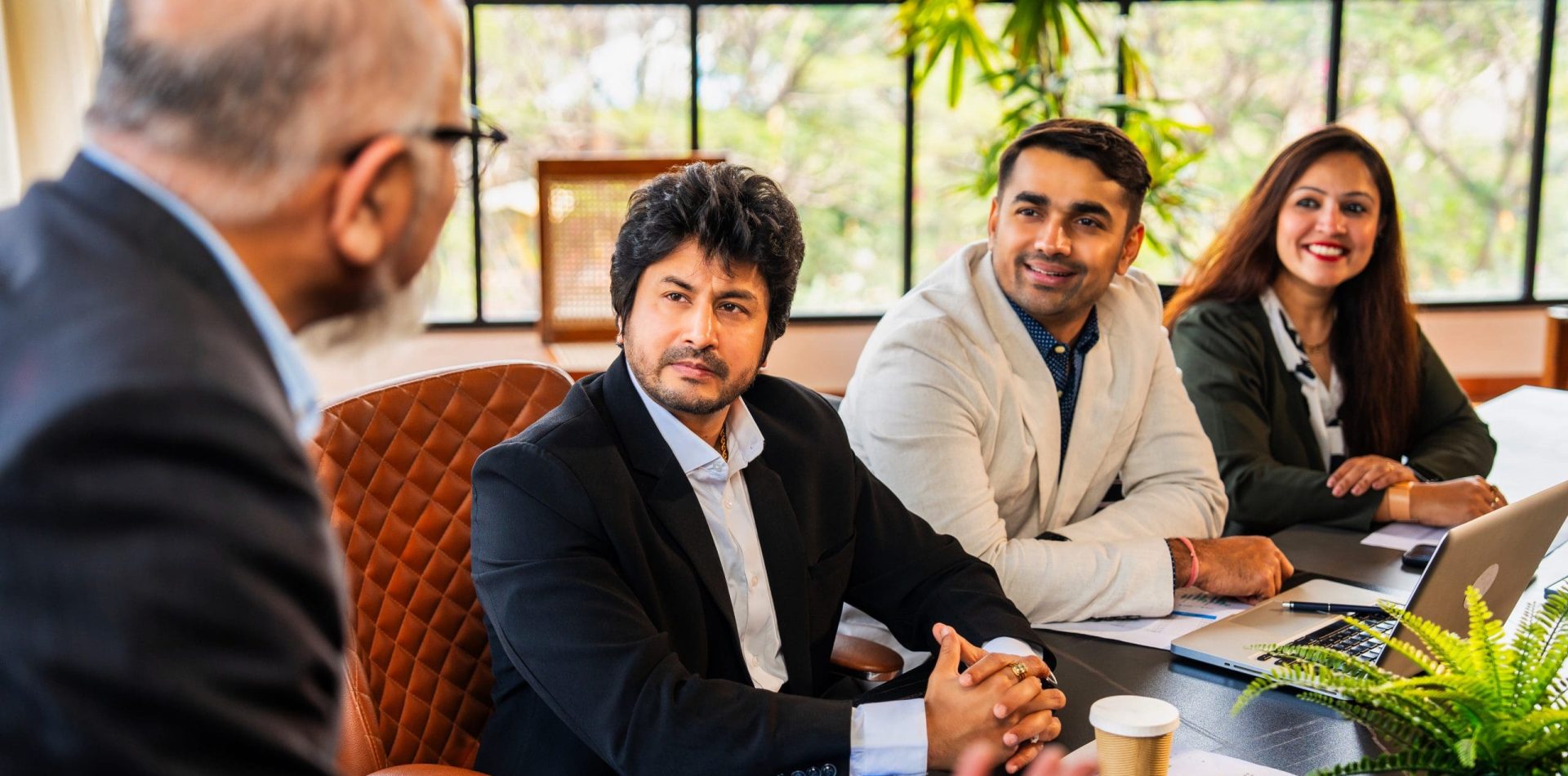 Asian Indian CEO presenting strategy or delivering a speech to his team in corporate conference room Company Setup Services in Singapore