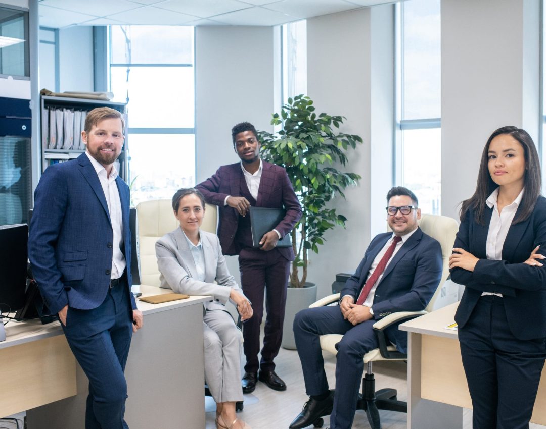 Large group of young successful intercultural white collar workers in open space office