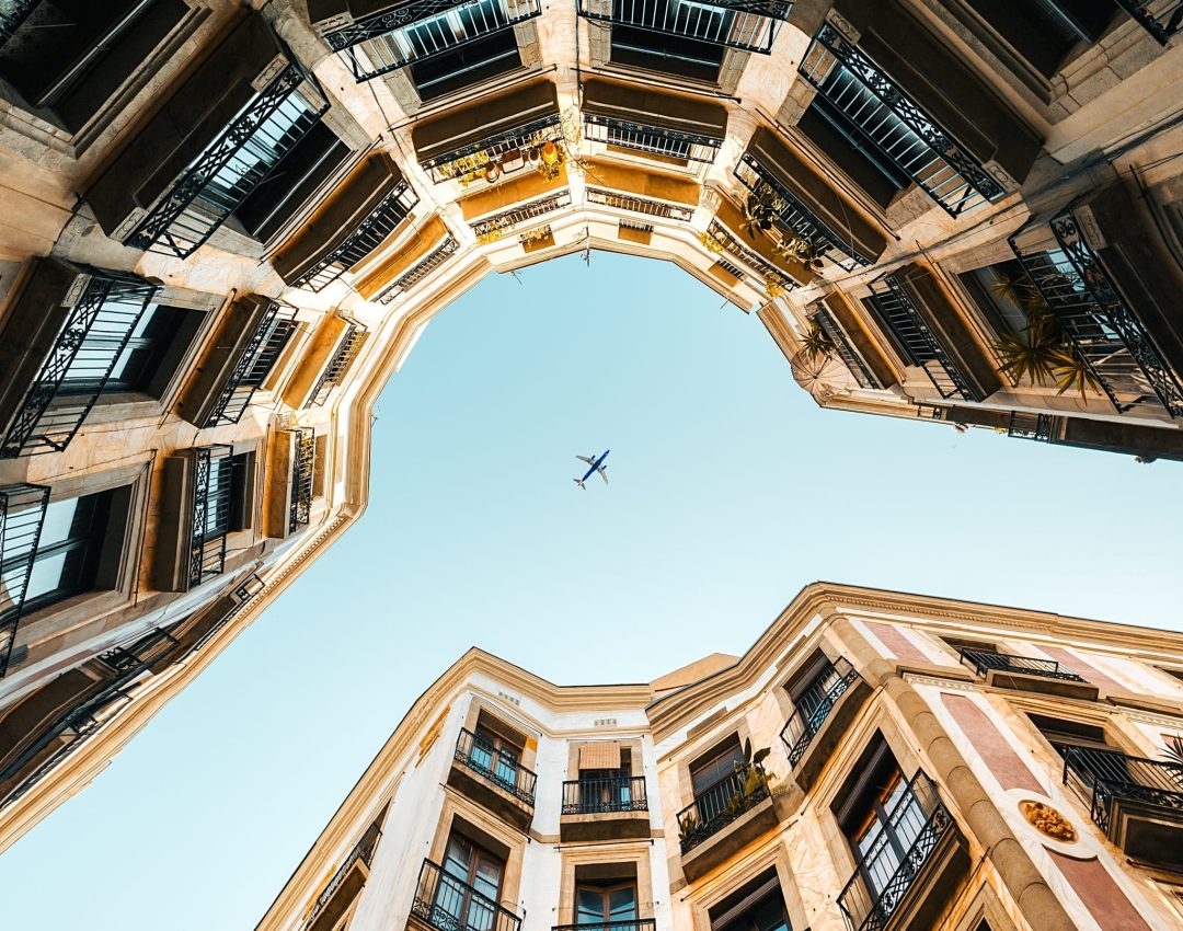 Low angle of an airplane flying above a residential building A low angle of an airplane flying above a residential building